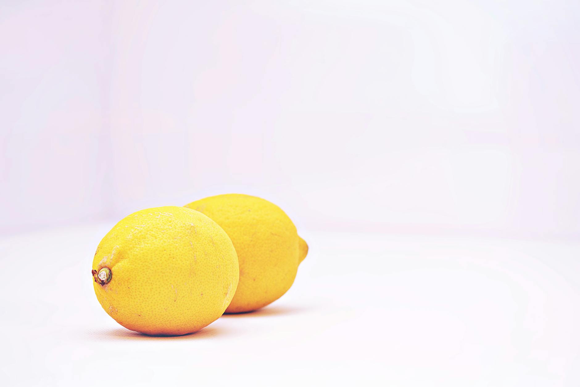 Vibrant lemons against a clean white background, representing fresh sensation and clarity