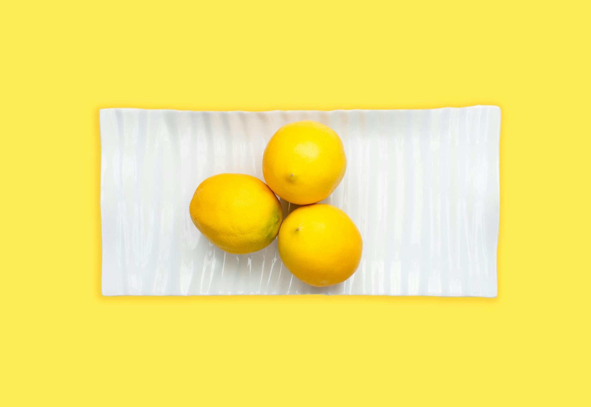 Two fresh lemons held in cupped hands, symbolizing tender sensation and care
