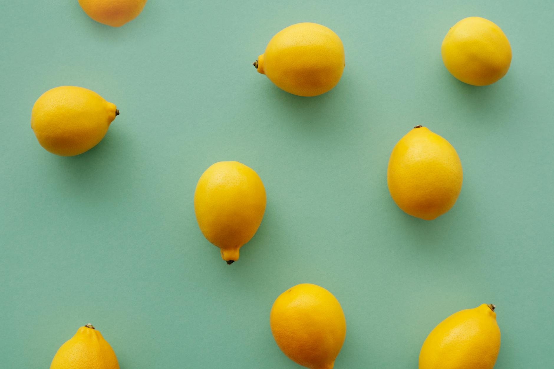 Bright yellow lemons arranged on pastel background, representing fresh sensations and cyclical pleasure