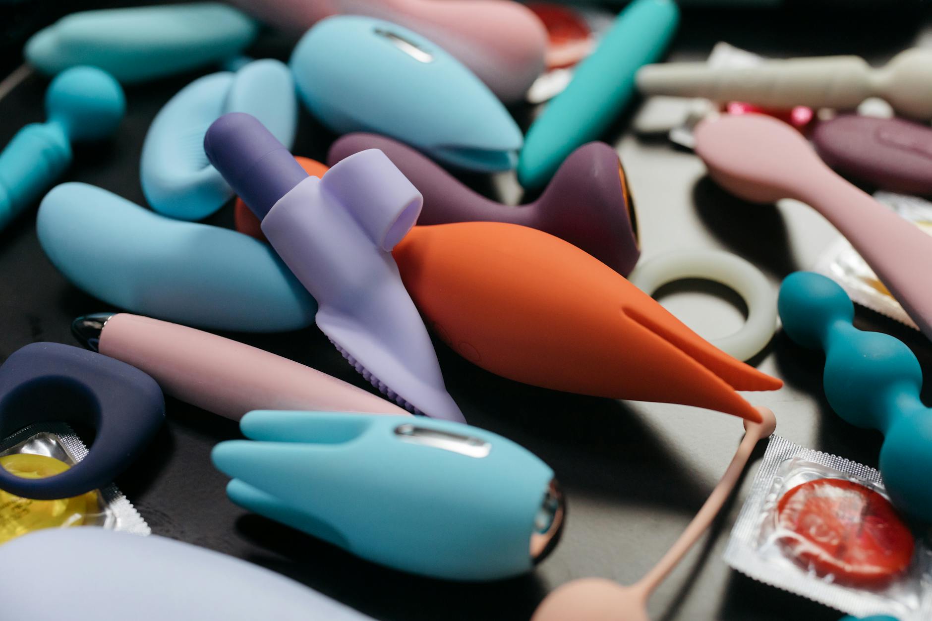 A vibrant collection of various lemon clitoral vibrators on a black tray, featuring diverse shapes and colors