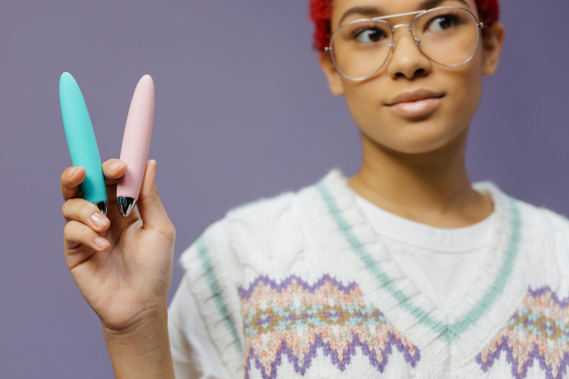 A woman holds a vibrator against a purple background, representing reclaiming personal pleasure