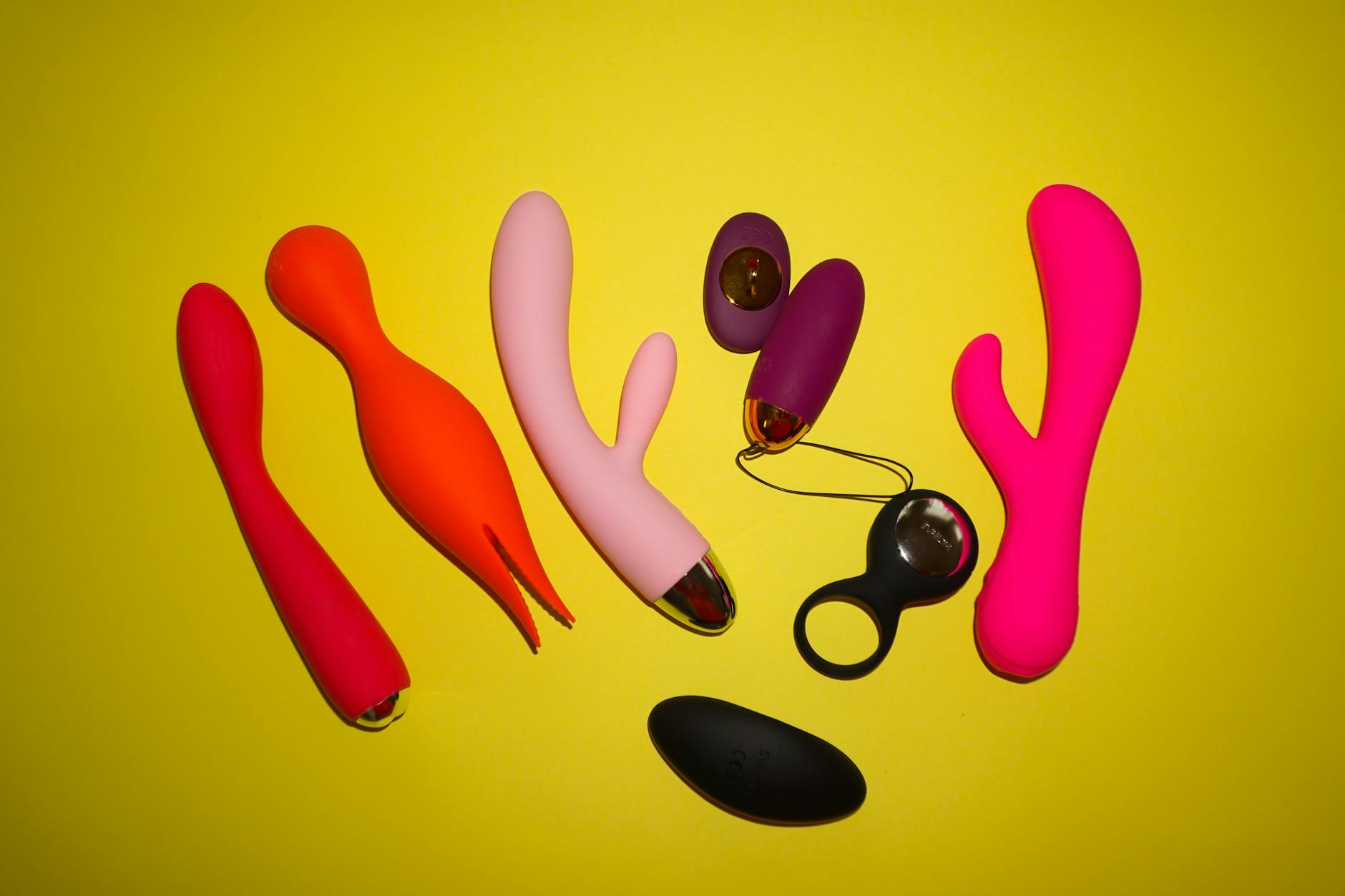 Colorful vibrators and intimate wellness toys displayed on a bright yellow background