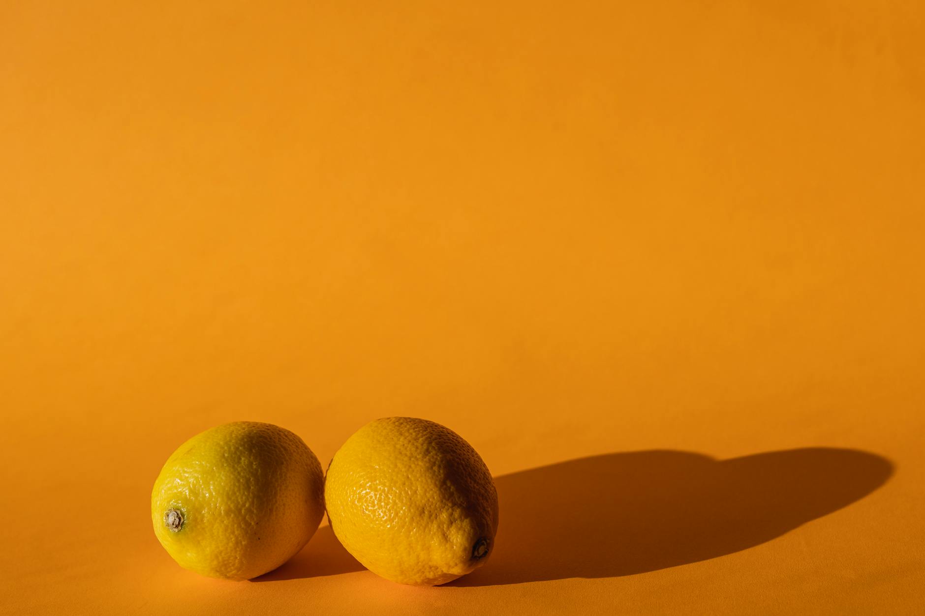 Bright lemons on a yellow background, symbolizing renewal and fresh sensation